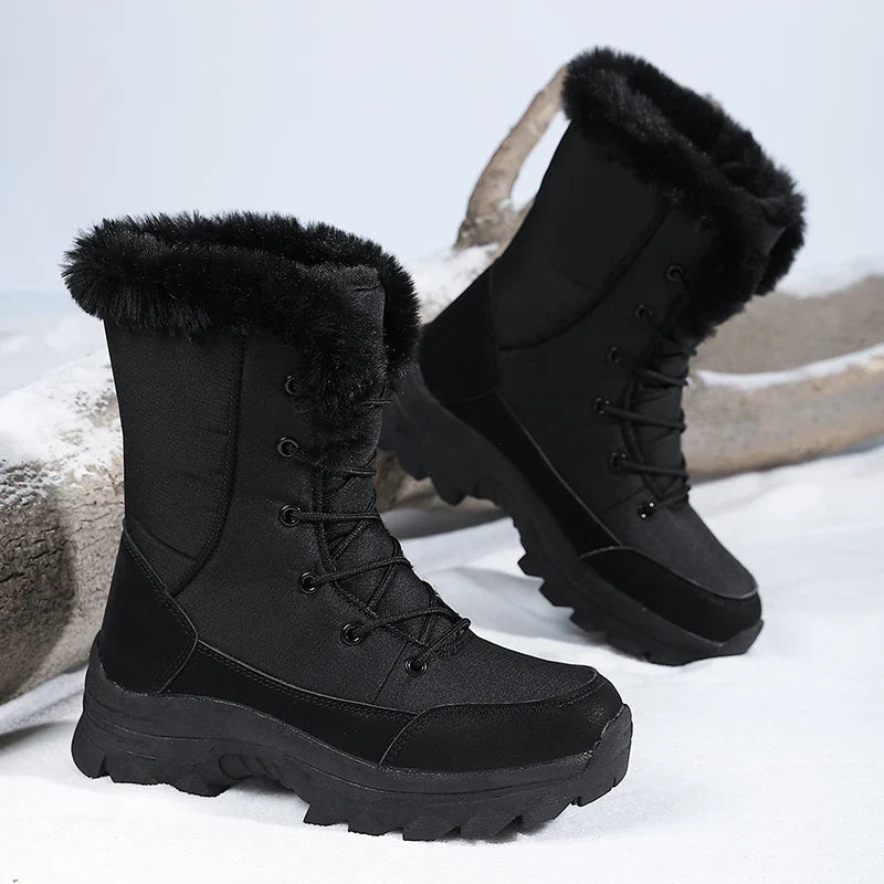 Snowboots dames in zwart – paar in driekwartaanzicht in de sneeuw