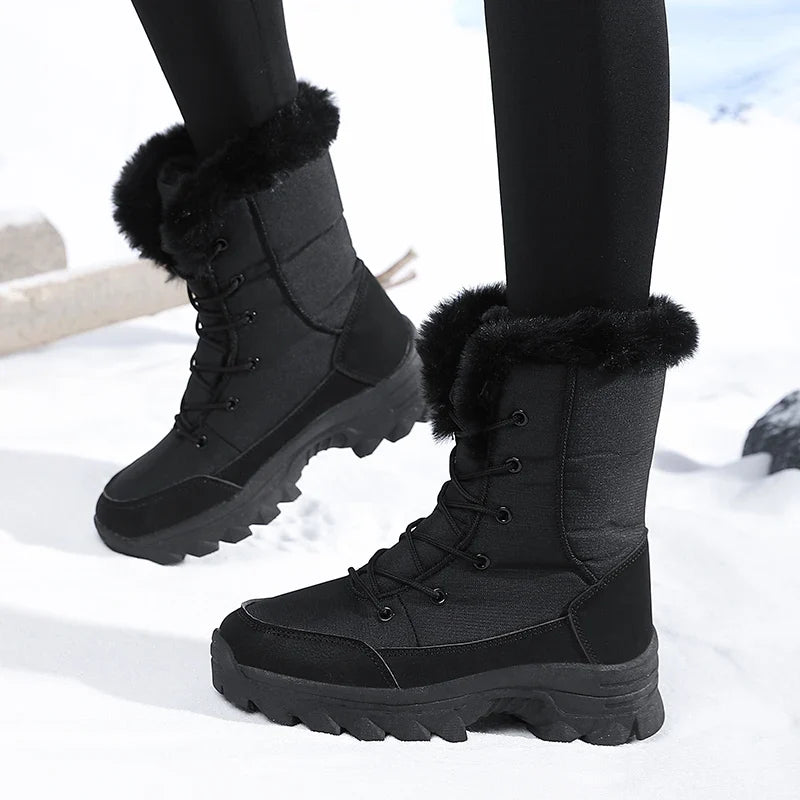 Snowboots dames in zwart gedragen – zijaanzicht tijdens het lopen in de sneeuw