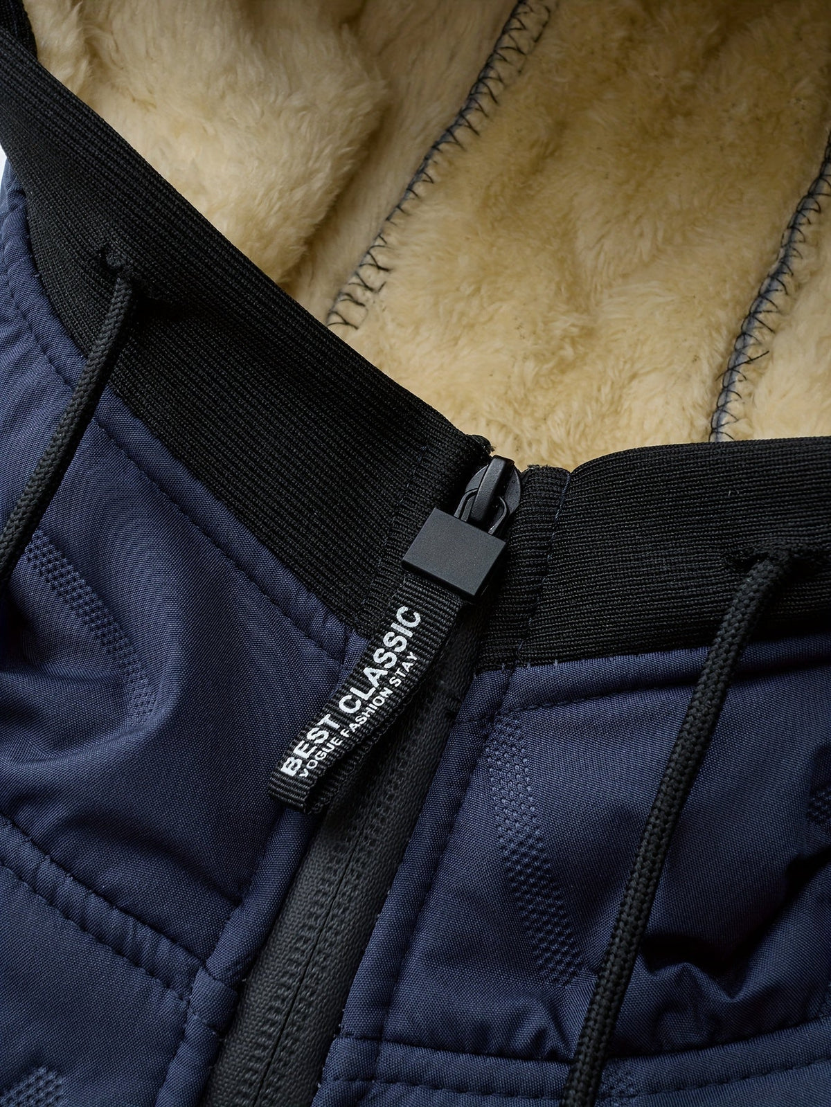 Winterjas heren detail: pluche voering, trekkoord en rits van dichtbij