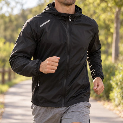 Zwarte hardloopjas heren gedragen tijdens een training op een bospad