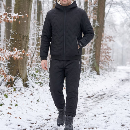 Trainingspak heren in zwart, gedragen tijdens een wandeling in het besneeuwde bos