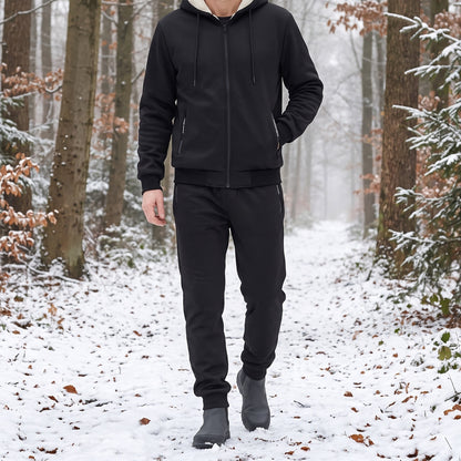 Trainingspak heren in zwart, gedragen tijdens een wandeling in het besneeuwde bos