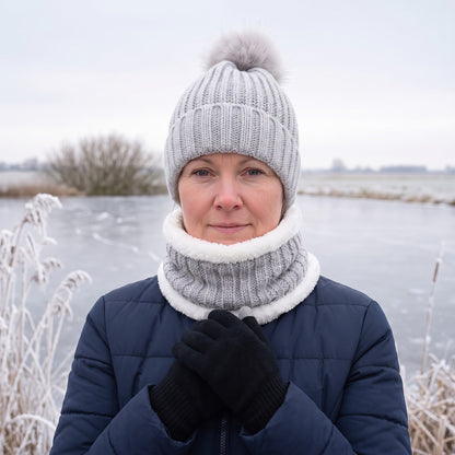 Vrouw met de grijze muts sjaal handschoenen set langs een bevroren plas