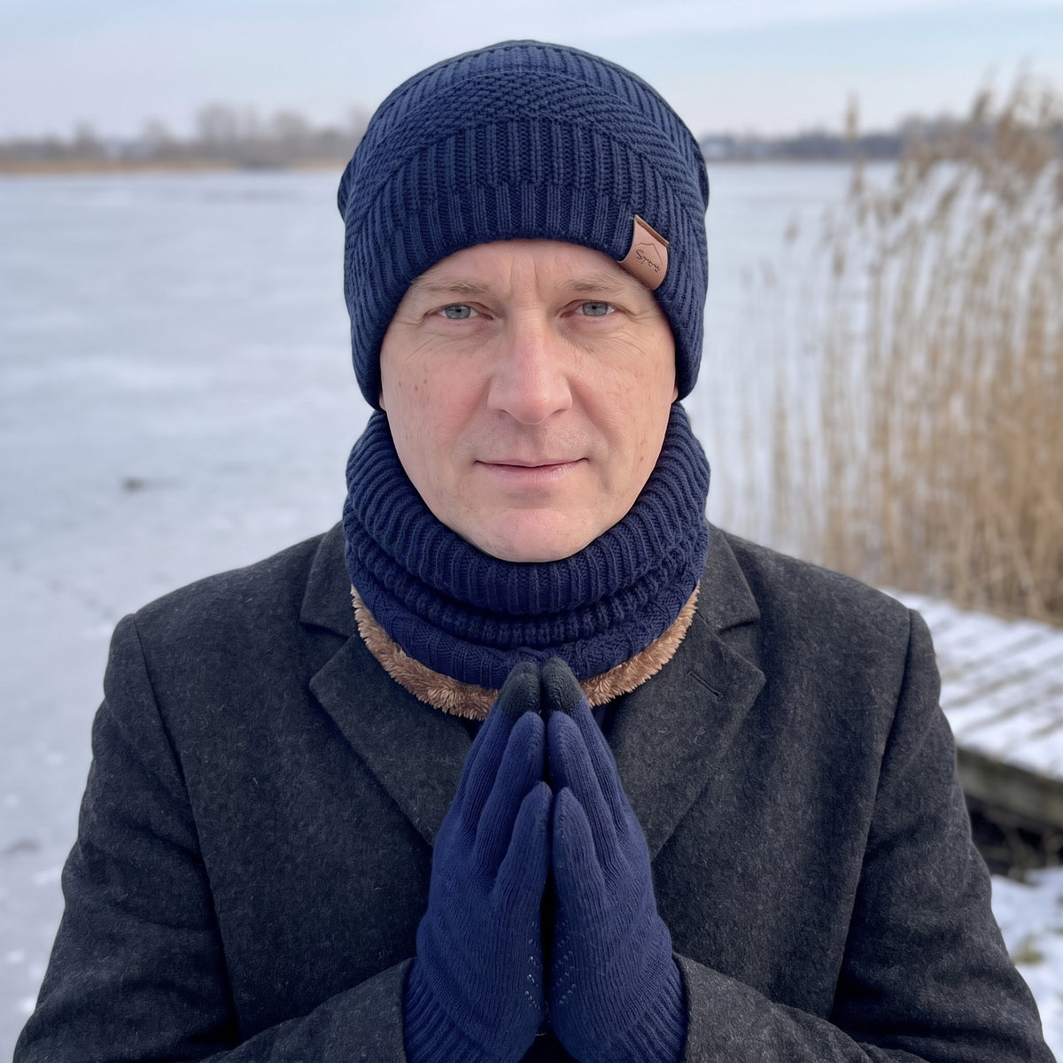 Man draagt marineblauwe wintermuts heren met bijpassende nekwarmer en touchscreen-handschoenen langs een bevroren plas