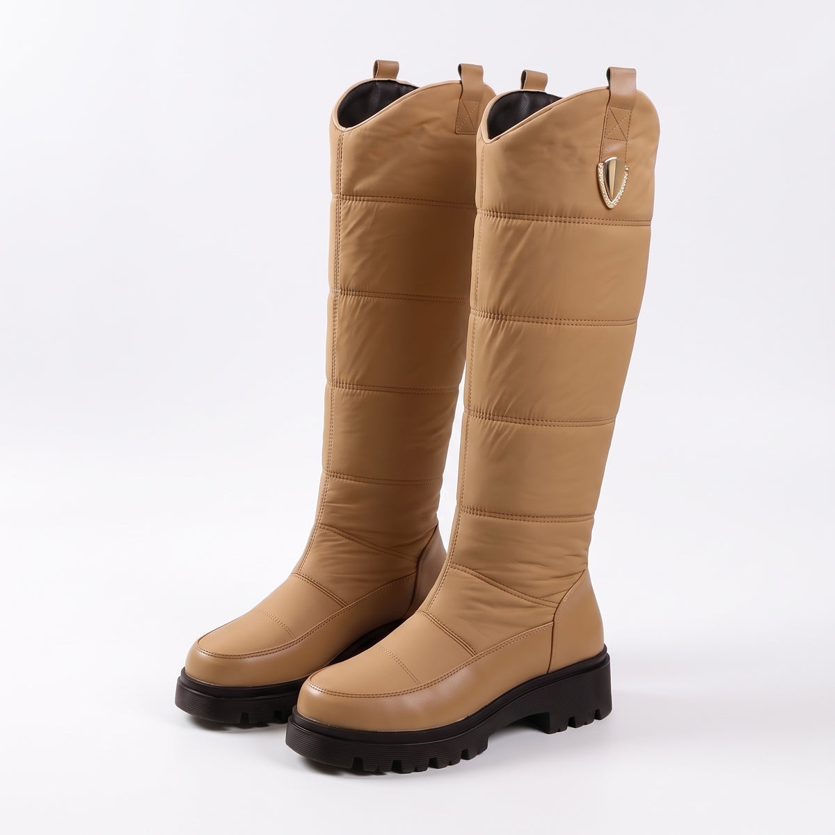 Snowboots dames in camel met goudkleurige clip en zwarte profielzool op witte achtergrond