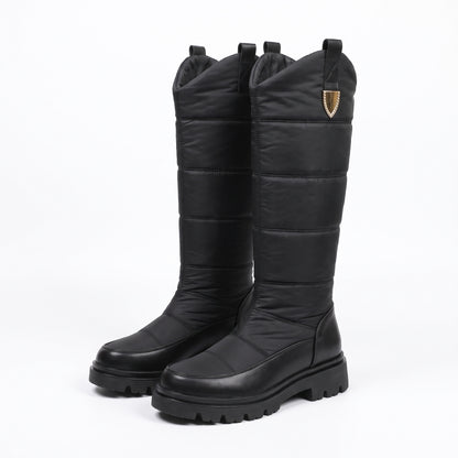 Snowboots dames zwart, hoge gewatteerde schacht met sierclip en profielzool, op witte achtergrond